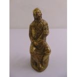 A cast brass figurine of a gentleman playing a musical instrument