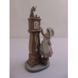 Lladro figurine of a girl next to a grandfather clock