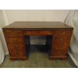 An early 20th century rectangular mahogany partners desk with brass swing handles on bracket feet,