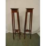 A pair of Edwardian mahogany inlaid plant stands on four tapering rectangular supports