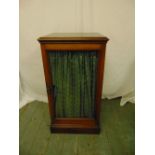 A Regency rectangular mahogany cabinet with hinged glazed door on rectangular plinth