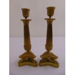 A pair of French Empire style ormolu table candlesticks