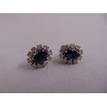 A pair of 18ct white gold, sapphire and diamond cluster earrings, each sapphire 2.5ct surrounded