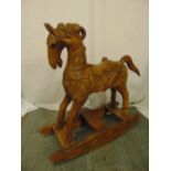 A carved wooden rocking horse with detachable tail