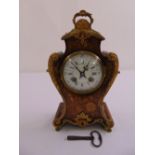 A French mantle clock, circular white enamel dial with Roman numerals, to include pendulum and key