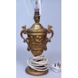 A gilded metal table lamp with embossed cherubs fr