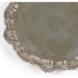 A late Victorian circular silver card tray, with engraved border and scrolled decoration, by