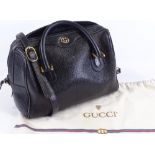 A Gucci black leather handbag, original shoulder strap and original Gucci cloth bag