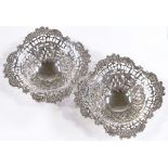 A pair of late Victorian silver bonbon baskets, with pierced and relief embossed floral border, by