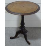 A Victorian walnut occasional table with carved edge, on carved tripod base, 24" across