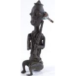 A Benin bronze figure of a hunter holding a rifle, converted to a door knocker, height 19cm