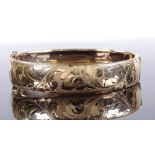 A 9ct gold hinged bangle, with engraved foliate front, band width 13.1mm, 14.6g