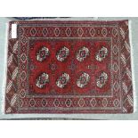 A small red ground Bokhara rug, with symmetrical pattern, 4' 2" x 3'