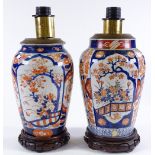 A pair of Chinese Imari design table lamps on carved wood stands, height including fittings 35cm