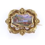 A Swiss unmarked gold brooch, with inset painted enamel plaque depicting lakeside town, in floral