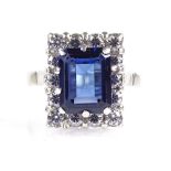 An 18ct white gold synthetic sapphire and paste cluster ring, setting height 15mm, size R, 5.7g