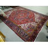 A 1940s Heriz red ground good wool large rug, 12' 10" x 9' 10"