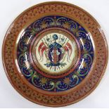 A 19th century Continental Faience pottery dish, with raised armorial centre panel, diameter 25cm