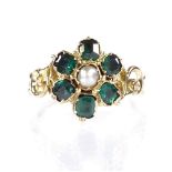 An unmarked gold emerald and pearl flowerhead ring, with pierced foliate shoulders, setting height