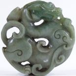 A Chinese relief carved and pierced jadeite dragon design pendant, 5.5cm diameter