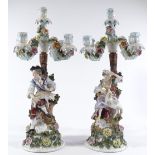 A pair of 19th century German porcelain candelabra, surmounted by country figures with sheep, blue