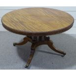 A 19th century circular mahogany dining table, with carved beaded edge, raised on scroll supports
