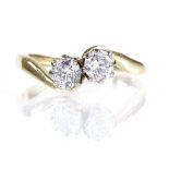 An 18ct gold 2-stone diamond crossover ring, total diamond content approx 0.6ct, setting height 6.