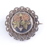 A Victorian circular silver photo panel-back brooch, with 2-colour gold applied floral decoration,