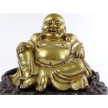 A Chinese bronze seated Buddha on carved hardwood stand, overall height 26cm, stand width 31cm