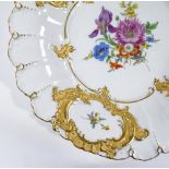 A Meissen porcelain table centre dish, with hand painted and gilded decoration, in relief moulded