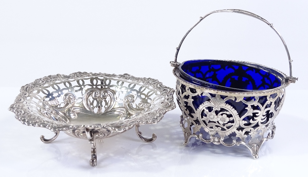 A silver swing-handled basket with blue glass liner, diameter 11cm, together with a silver pierced