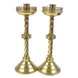 A pair of Gothic style brass candle stands, with pierced rims, height 39cm
