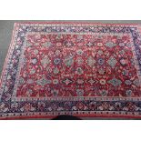 A large red ground wool rug, with triple border, 10'11" x 7'9"