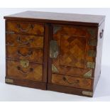 A Japanese Meiji period parquetry covered table cabinet, fitted with drawers and cupboards, width