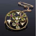 An Edwardian 15ct gold peridot, ruby and pearl 3-leaf clover circular brooch, with openwork