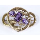 A large Victorian knot design amethyst set brooch, with foliate surrounds and floral engraved bands,