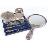 A silver-backed dressing table mirror, a silver powder jar, a manicure set etc
