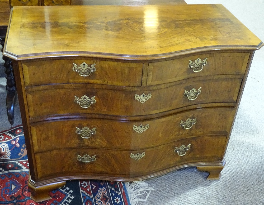 A 19th century mahogany serpentine chest of drawers, with fluted columns and brass escutcheons,