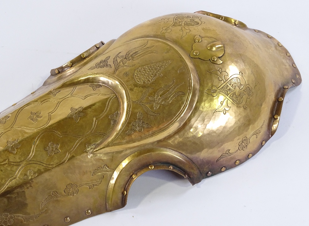 An Islamic engraved brass horse armour face cover, length 58cm