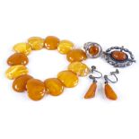 A butterscotch amber bracelet, a silver and amber ring, a brooch, and pendant earrings (4)