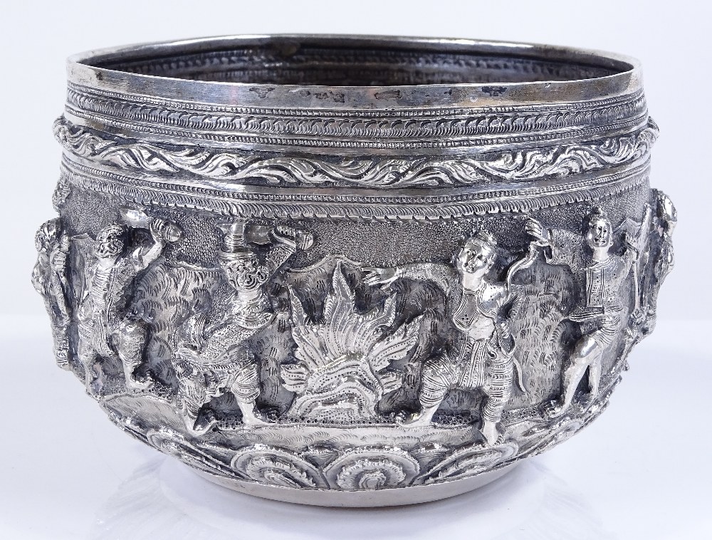 A large Burmese silver Thabeik bowl, with high relief battle scenes and peacock mark on base,