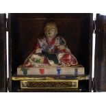 A carved and painted wood seated Buddha, circa 1900, in painted and lacquered wood shrine cabinet,