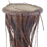 A small 19th century hollow carved wood Ethnic drum with leather bindings (A/F)