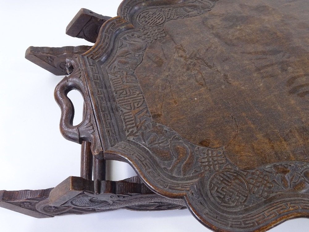 A Chinese hardwood 2-handled tea tray on folding stand, with relief carved dragon and symbolic - Image 2 of 3