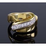 An 18ct gold diamond line fold over ring, setting height 13.8mm, size M, 11.2g