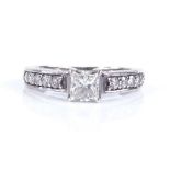 A platinum and Princess-cut solitaire diamond ring, with graduated diamond set shoulders, Princess-