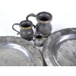 A pair of Antique pewter chargers, diameter 38cm, and 3 graduated brass-rimmed pewter measures (5)