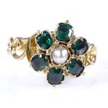 A 9ct gold green tourmaline and seed pearl flowerhead ring, with pierced scrollwork shoulders,