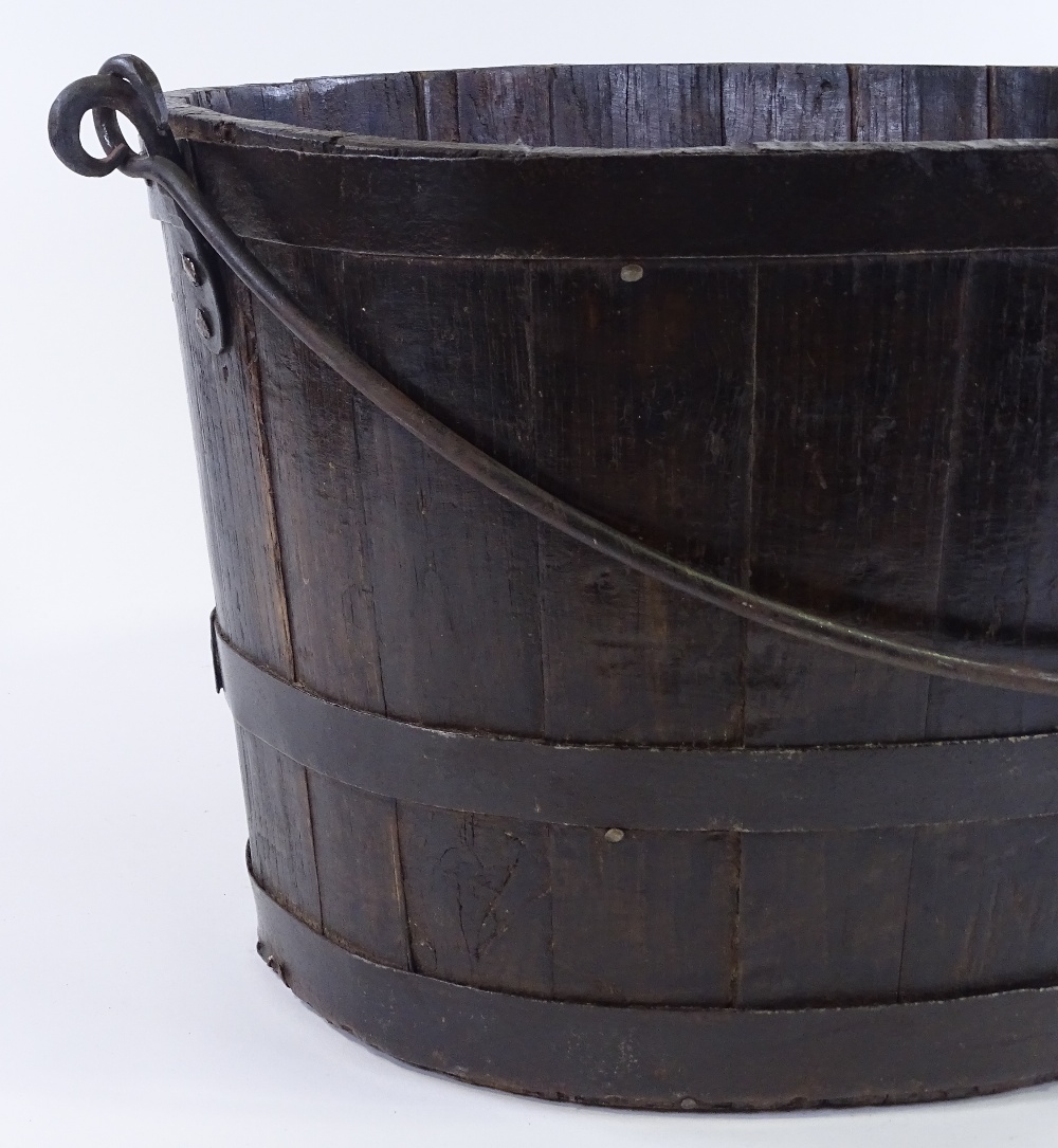 A metal-bound stained wood oyster bucket, with iron swing handle, length 58cm