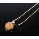 An 18ct gold orange moonstone and diamond Man in the Moon pendant necklace, maker's marks CEB,